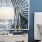 a bed and a lamp in front of a blue wall